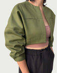 Detail of in-seam chest pockets with a rounded stitch detail on Contoured Bolero Jacket in Lucid Olive.