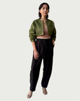Model in Contoured Bolero Jacket in Lucid Olive with cropped contoured hem and three-quarter sleeves, styled with Wool Suiting Arc Pant in Espresso Brown.
