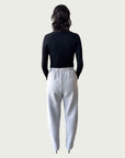 Rear view of Ribbed Mock Neck Shirttail Top in Black on model, seamlessly tucked into the Organic Contoured Cotton Arc Pant in Porcelain.