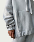 Detail of in-seam Kangaroo pocket and stacked sleeve on Organic Contoured Cotton A.D.C. Hoodie in Porcelain.