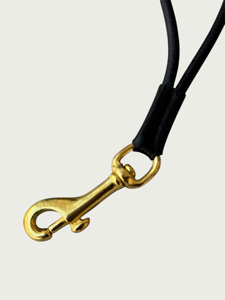 Close up of solid brass trigger hook on Wildgrain Leather Essential Loop Wrist Strap in Black.