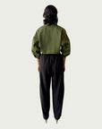 Rear view of Contoured Bolero Jacket in Lucid Olive highlighting the cropped hem and dropped shoulder, styled with Wool Suiting Arc Pant in Espresso Brown.