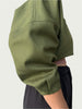 Detail of Contoured Bolero Jacket in Lucid Olive sleeve, side view; voluminous sleeve with double pleats.
