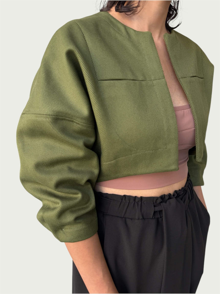Detail of in-seam chest pockets with a rounded stitch detail on Contoured Bolero Jacket in Lucid Olive.