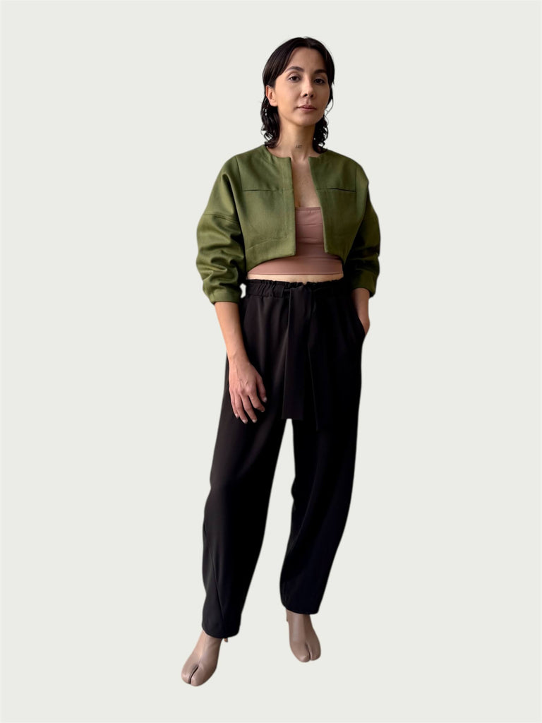 Model in Contoured Bolero Jacket in Lucid Olive with cropped contoured hem and three-quarter sleeves, styled with Wool Suiting Arc Pant in Espresso Brown.