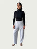Model in Ribbed Mock Neck Shirttail Top in Black with long sleeves and a close, body-skimming fit, styled with the Organic Contoured Cotton Arc Pant in Porcelain.