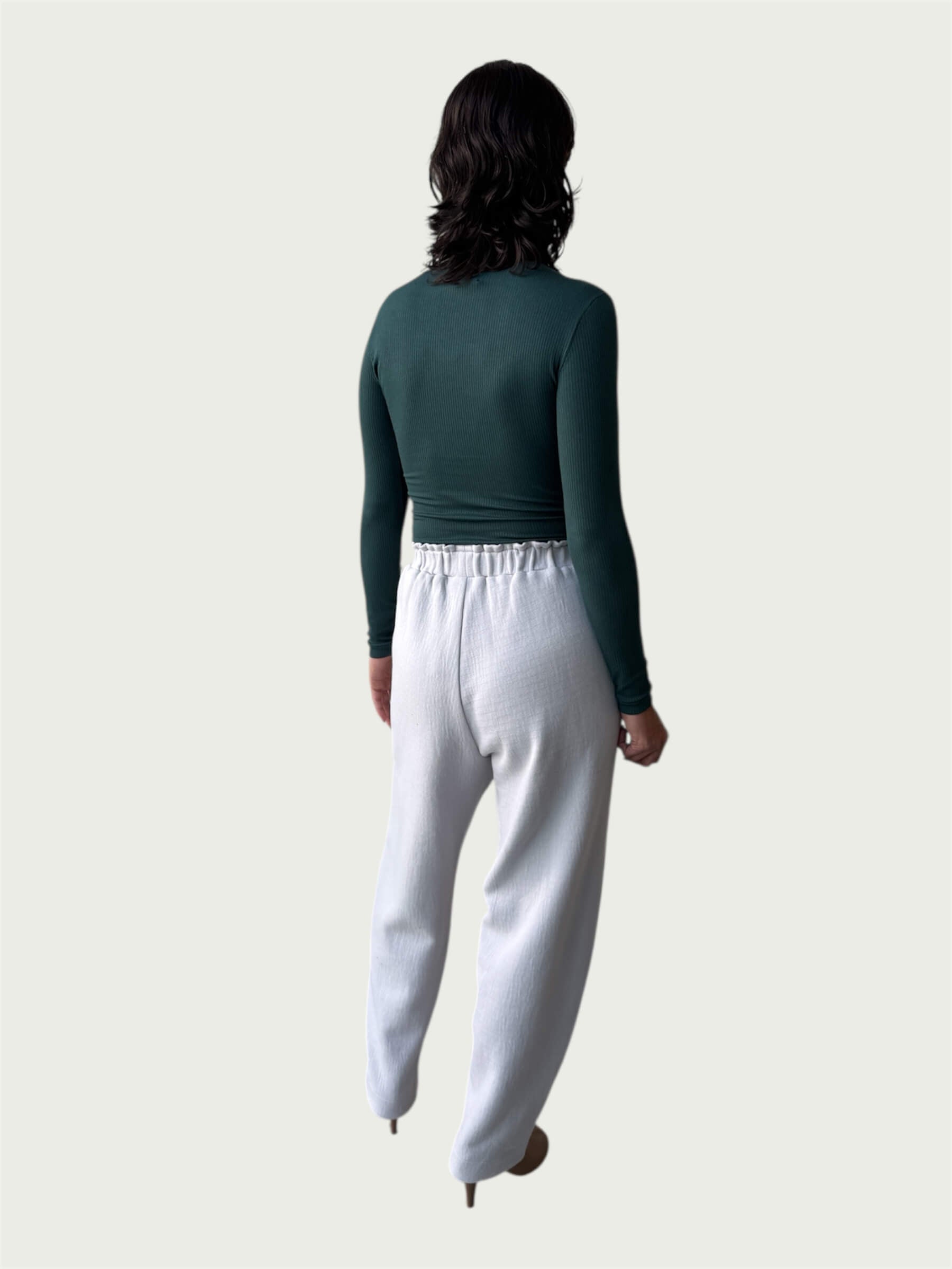 Rear view of Ribbed Mock Neck Shirttail Top in Silver Pine on model, seamlessly tucked into the Organic Contoured Cotton Arc Pant in Porcelain.