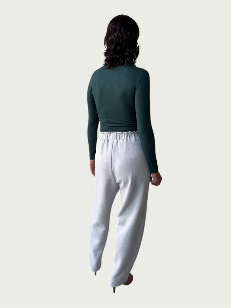 Rear view of Ribbed Mock Neck Shirttail Top in Silver Pine on model, seamlessly tucked into the Organic Contoured Cotton Arc Pant in Porcelain.