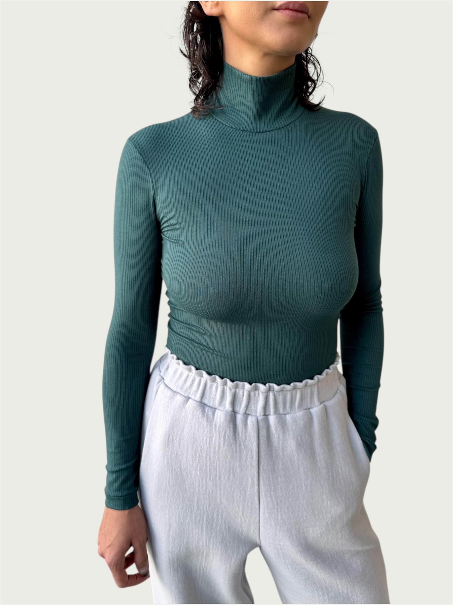 Close-up of lightweight, ribbed stretch fabric, featuring the mock-to-turtleneck neckline on the Ribbed Mock Neck Shirttail Top in Silver Pine.