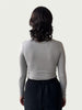 Rear view of Ribbed Mock Neck Shirttail Top in Dove Grey on model, seamlessly tucked into the Organic Contoured Cotton Arc Pant in Black.