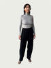 Model in Ribbed Mock Neck Shirttail Top in Dove Grey with long sleeves and a close, body-skimming fit, styled with the Organic Contoured Cotton Arc Pant in Black.