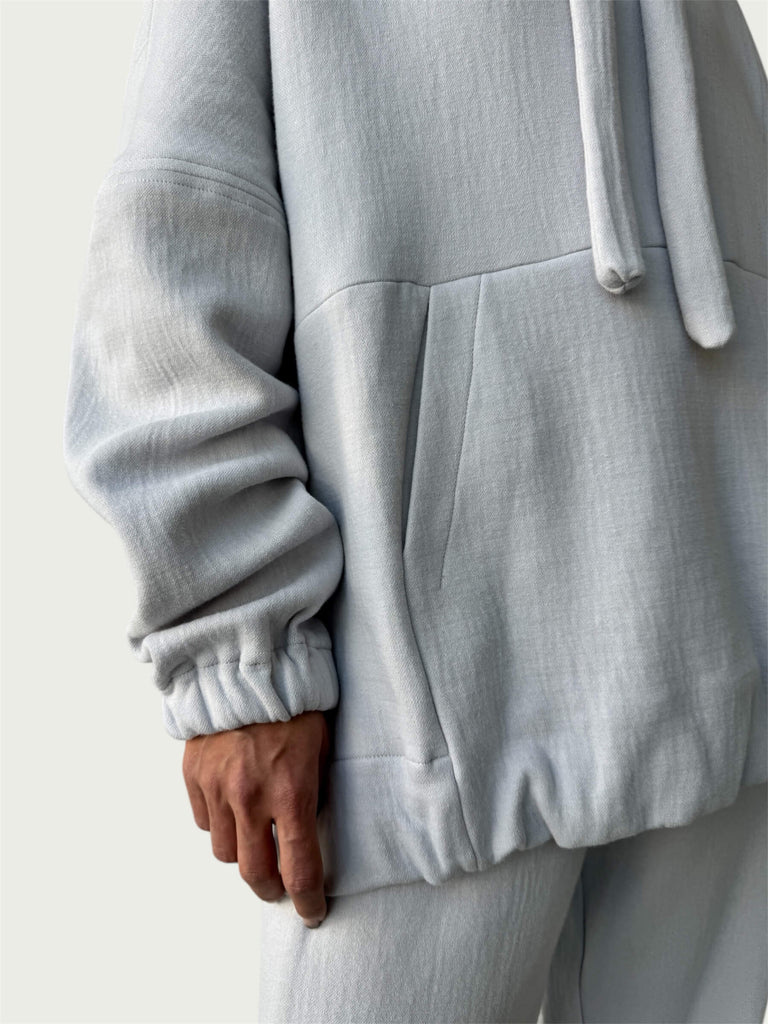 Detail of in-seam Kangaroo pocket and stacked sleeve on Organic Contoured Cotton A.D.C. Hoodie in Porcelain.