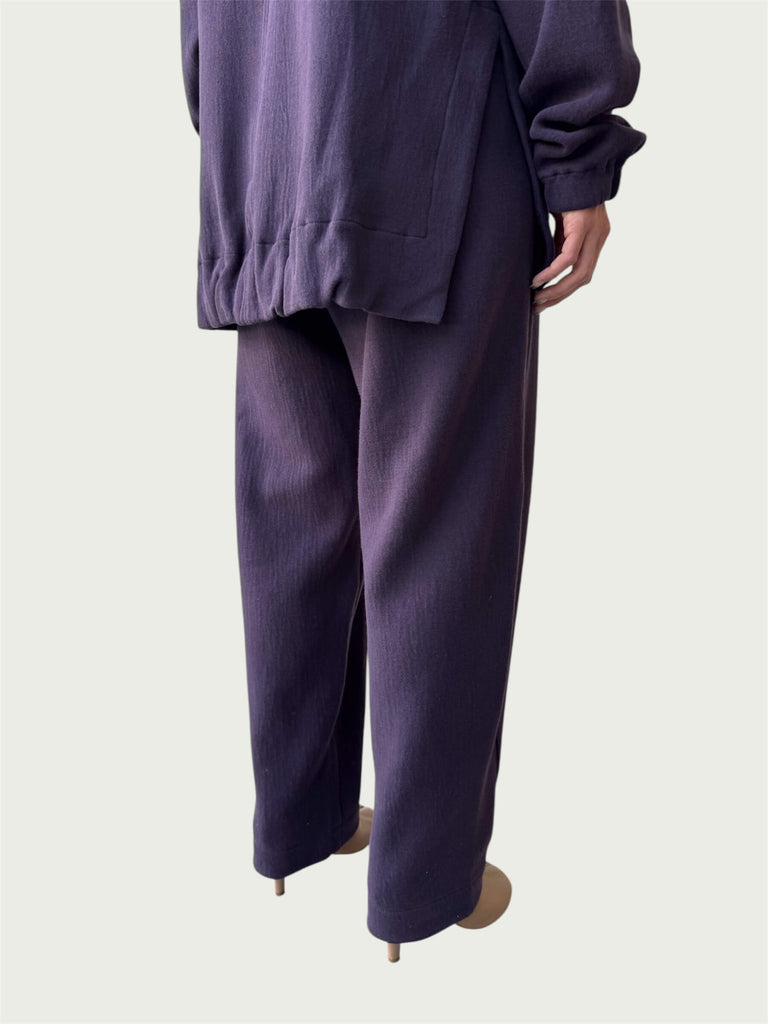 Rear view of gently gathered hem with side slits on Organic Contoured Cotton A.D.C. Hoodie in Evening Violet, styled with Organic Contoured Cotton Arc Pant in Evening Violet.
