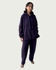 Model in Organic Contoured Cotton A.D.C. Hoodie in Evening Violet with in-seam Kangaroo pocket and double layered hood, styled with Organic Contoured Cotton Arc Pant in Evening Violet.