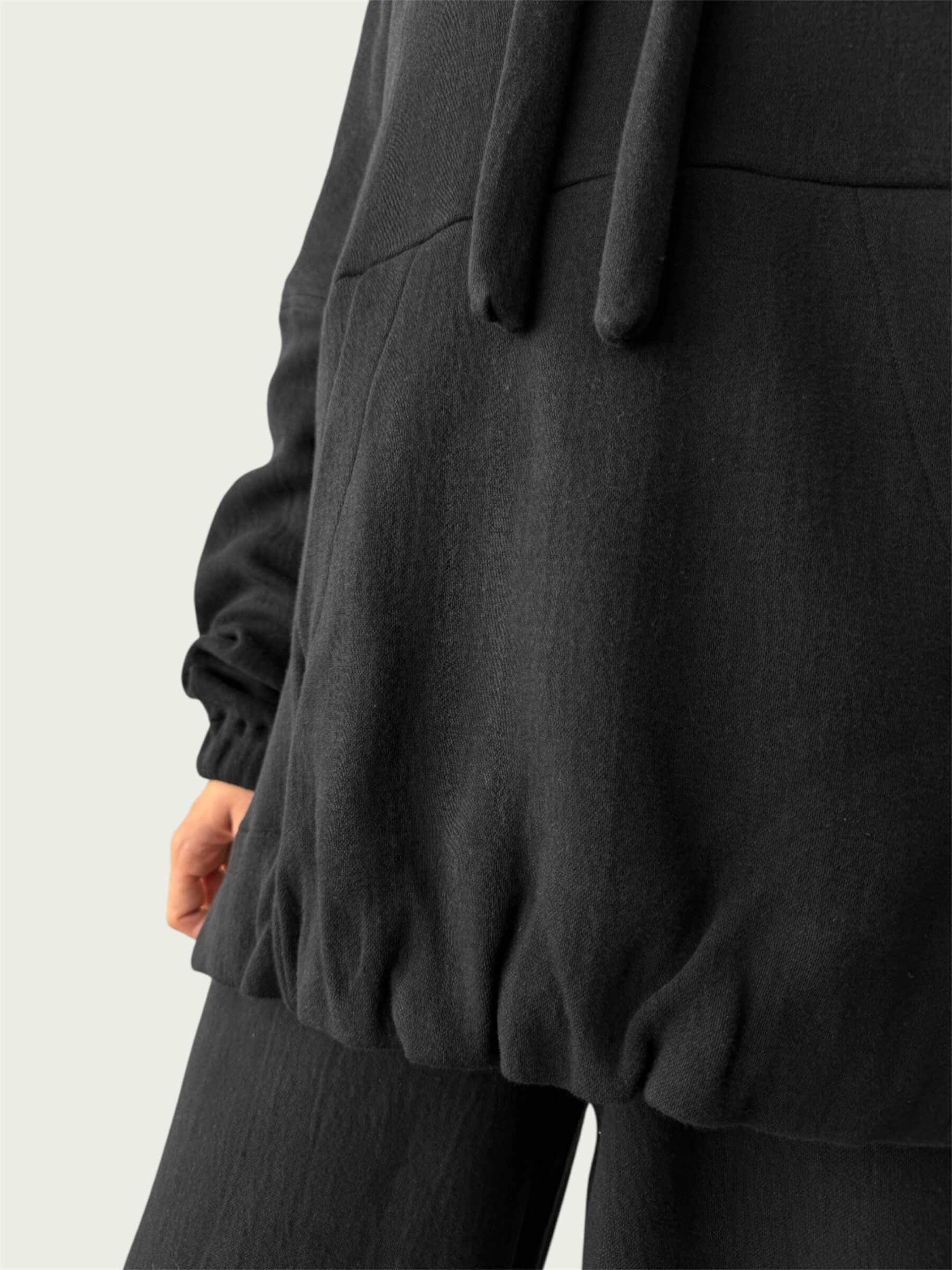 Detail of in-seam Kangaroo pocket and stacked sleeve on Organic Contoured Cotton A.D.C. Hoodie in Black,