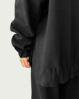 Detail of high-low hemline with side slit on Organic Contoured Cotton A.D.C. Hoodie in Black, showcasing its easy drape.