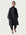 Person wearing a dark coat and pants on a white background